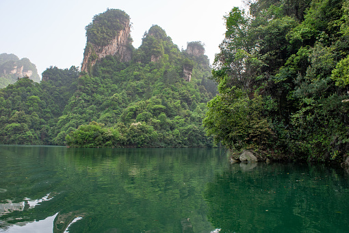 View of the Li River (Lijiang River) with azure water among scenic karst mountains at Yangshuo County of Guilin, China. Green hills on blue sky background. Amazing summer sunny landscape.