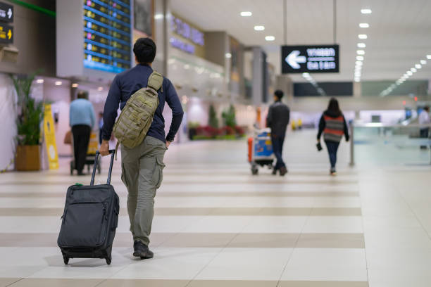 man carries luggage at the airport terminal. stock photo