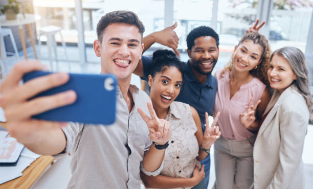 istock Diversity work selfie of team with a smile happy about teamwork collaboration and office support. Job friends and digital marketing employee business group posing with a peace hand sign and community 1434286638