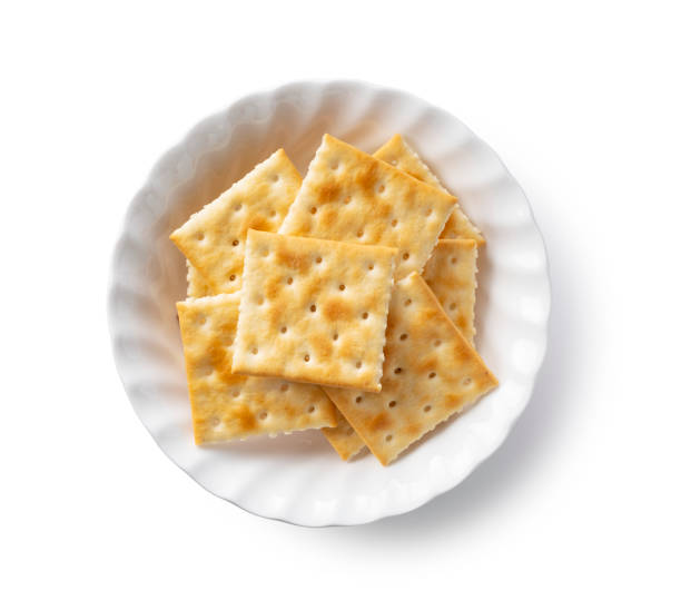 Crackers in a dish placed on a white background. Crackers in a dish placed on a white background. View from directly above. SALTINE CRACKER stock pictures, royalty-free photos & images