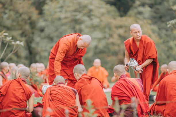 Thimphu, Bhutan - October 7: Bhutanese Monks Lunch Break Sitting On Ground Beside Dochula Passon October 7, 2022 in Thimphu, Bhutan.