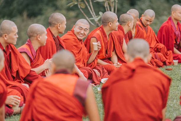 Thimphu, Bhutan - October 7: Bhutanese Monks Lunch Break Sitting On Ground Beside Dochula Passon October 7, 2022 in Thimphu, Bhutan.