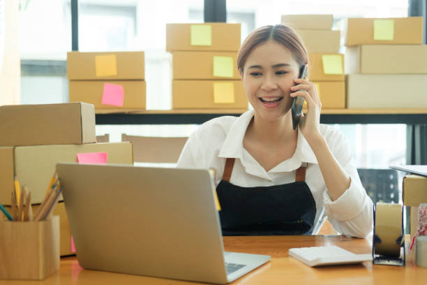 istock Female online business owner talking on phone with clients. 1434297985