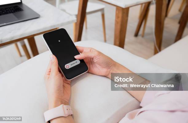 Woman Hand Using Is Sliding To Turn Off The Mobile Phone To Reduce Power Consumption Technology And Environment Concept Stock Photo - Download Image Now