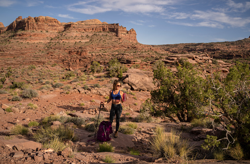 Female hiker with backpack in the Utah desert taking a a break for water