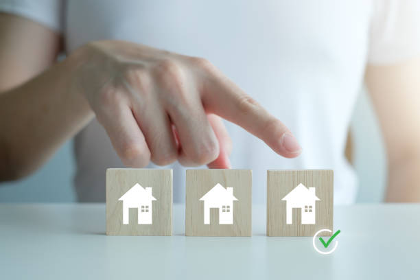 real estate, property investment and asset management concept. check mark from hand point to house icon on wooden block. decision to choose best property with your right. choosing suitable housing. - house human hand choice real estate imagens e fotografias de stock