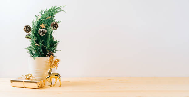 istock Creative natural miniature Christmas tree in pot on wooden table with gift boxes and white background. Xmas greeting card with copy space. Happy New Year. 1434309143