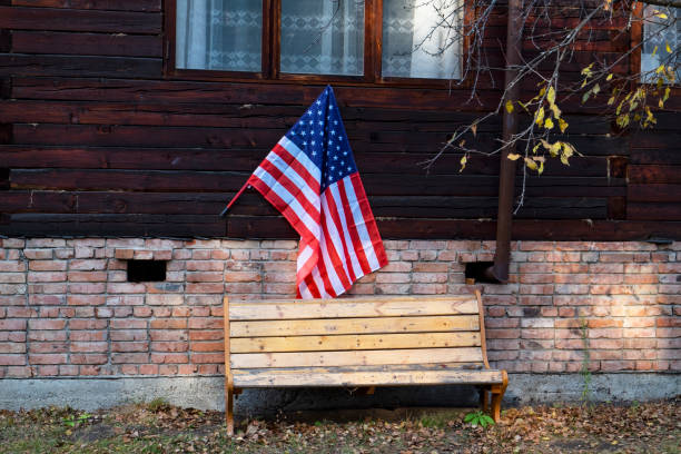 американский флаг висит на фасаде деревянного дома. америка, осень - chair brick organized group community стоковые фото и изображения