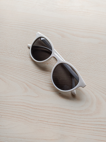 Sunglasses with white frames on a white table
