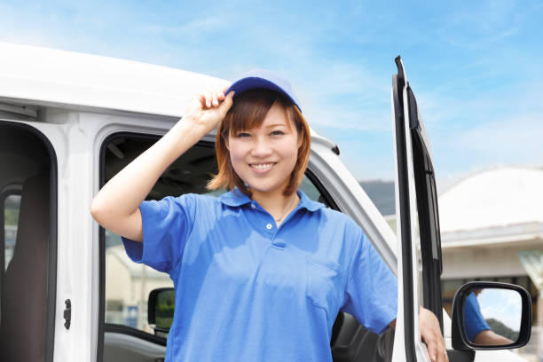 Female moving and light cargo driver. Greetings cheerfully.Logistics work image stock photo