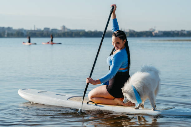 istock Woman with Dreadlocks Paddleboarding with Her Dog Snow-White Japanese Spitz on the Sup Board on City Lake 1434331663