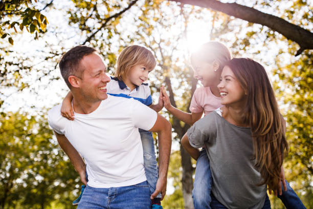 istock Young happy family having fun while piggybacking in spring day. 1434331776