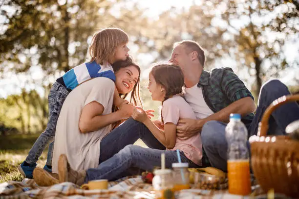 Photo of Cheerful family having fun on a picnic in spring day.