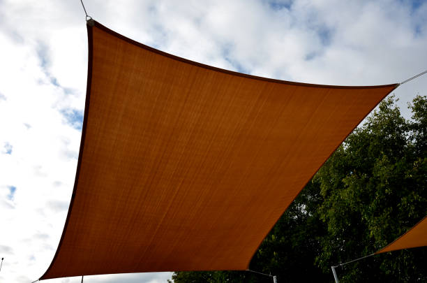 istock square canvas stretched, shading from sun and rain over terrace ofrestaurant, on playground in kindergarten, on platform of the promenade. pergola with metallic gray beams , cable, electric, bulb, led 1434333936