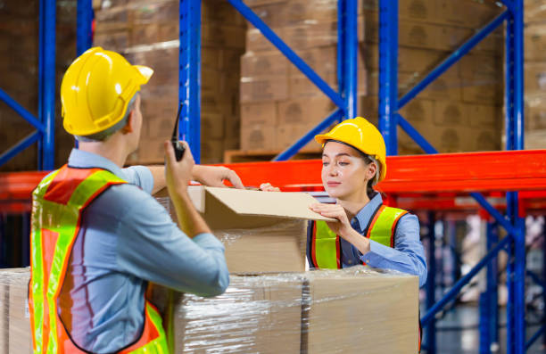 istock Workers team working in warehouse, Manager and supervisor taking inventory in warehouse, Female foreperson making plans with warehousemen 1434337429