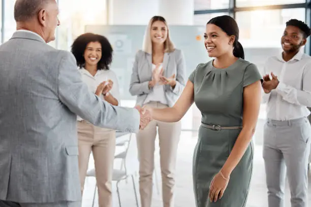 Photo of Happy handshake, by man and woman in office, for promotion in business, team gives applause. Meeting with diversity in people celebrate worker's progress to new role in corporate marketing job.