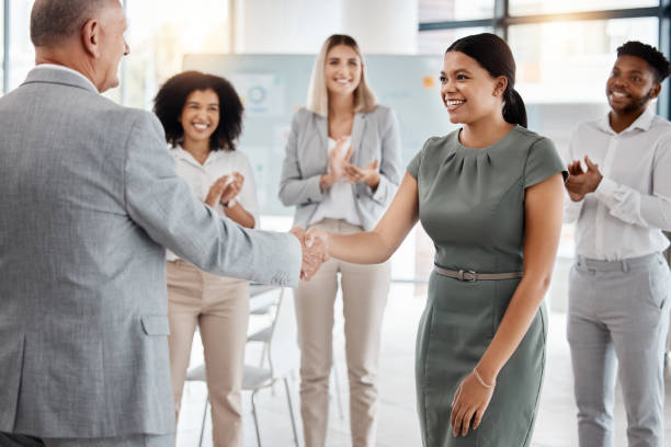 happy handshake, by man and woman in office, for promotion in business, team gives applause. meeting with diversity in people celebrate worker's progress to new role in corporate marketing job. - new greetings imagens e fotografias de stock