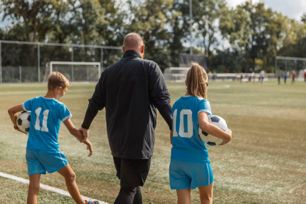 istock Soccer football coach with two children during a training session 1434345977