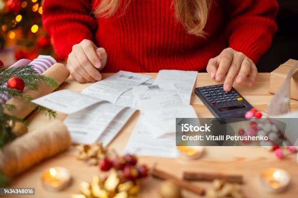 Woman Sitting At The Table Checking Her Bills After Buying Everything For Christmas Stock Photo - Download Image Now