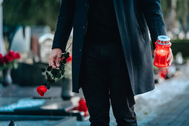 istock Man Laying Flowers On Grave 1434348317