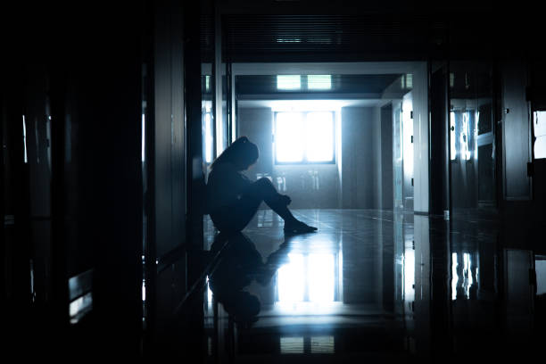 istock Sadness businesswomen sitting a dark corridor 1434349393