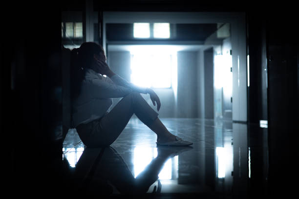 istock Sadness businesswomen sitting a dark corridor 1434349427