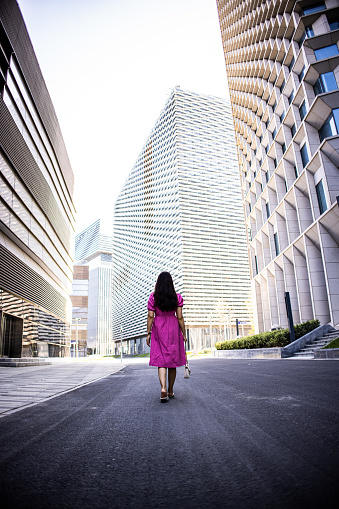 Asian woman in a dress walking in the city street