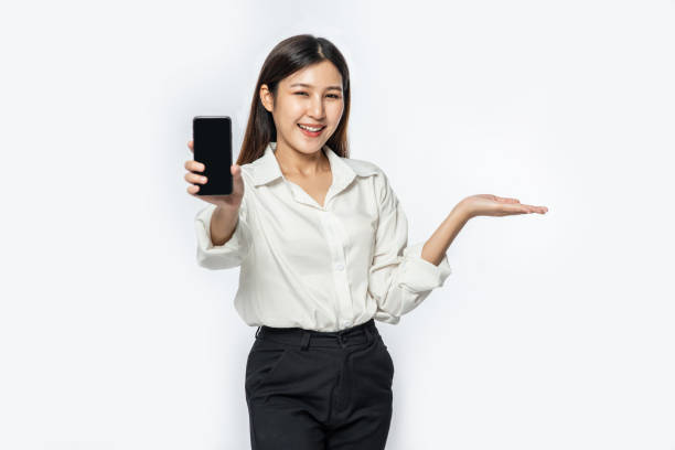 istock A woman wearing a shirt and holding a smartphone stretched forward. 1434349627