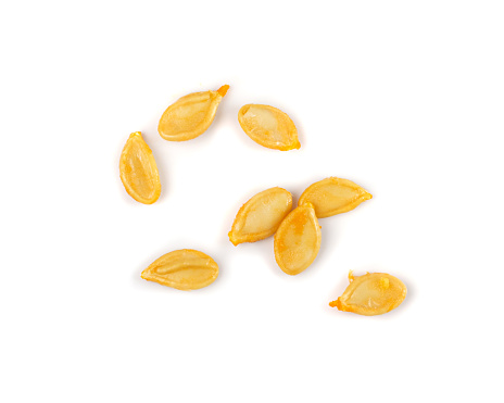 Raw pumpkin seeds pile isolated. Raw yellow pepitas, squash seeds group on white background top view