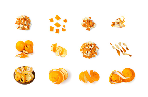 Round dried orange slices and twisted strips of orange peel close-up isolated on white background