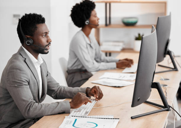 istock Call center worker in communication with people on internet online with computer at work, customer care help and support consulting at crm company. African telemarketing employee working in office 1434350853