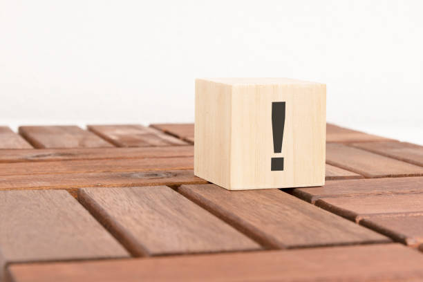 istock exclamation mark sign drawn on wooden block over brown background with copy space. 1434351676