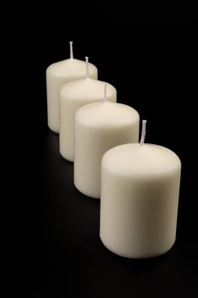 istock White candles on dark background. Close-up, copy space. 1434352064