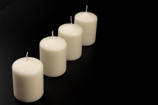 istock White candles on dark background. Close-up, copy space. 1434352091