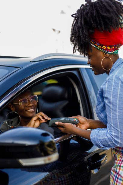 istock Service person holding a payment terminal while customer is paying with a credit card 1434356351