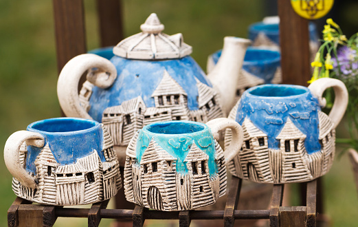 Close-up view of handmade souvenir ceramic cups and teapot