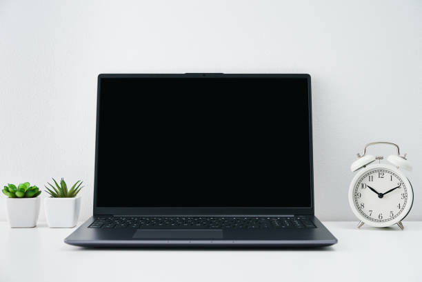 istock Office workplace with laptop, alarm clock and plants on table. Office interior 1434359632
