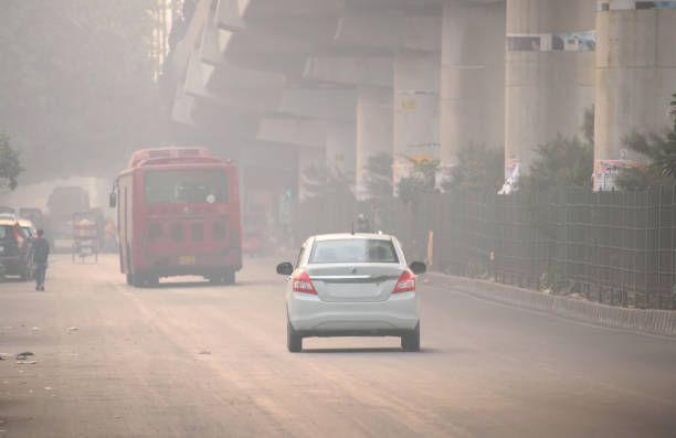 транспортные средства, бегущие по дороге в условиях сильного смога. - pollution street city street fog стоковые фото и изображения