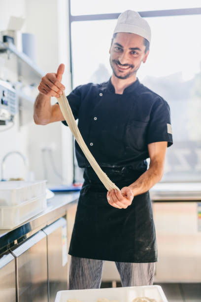 istock Italian chef pizzaiolo preparing pizza dough in restaurant kitchen 1434363392