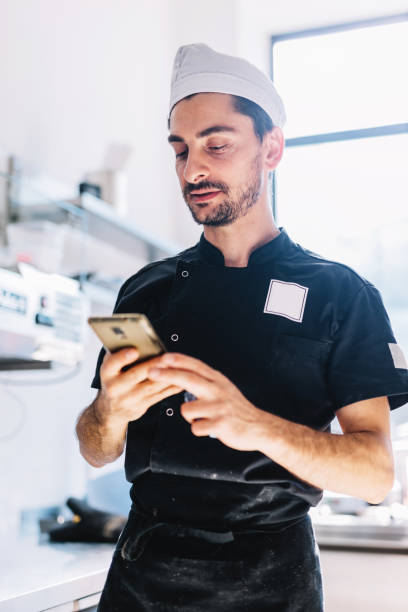 istock Italian chef with mobile phone in restaurant kitchen 1434363394