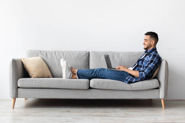 istock Portrait of smiling Arab man using laptop at home 1434365986
