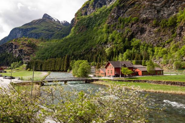 istock Small village in sunlight next to the river surrounded by forests and high hills 1434368304