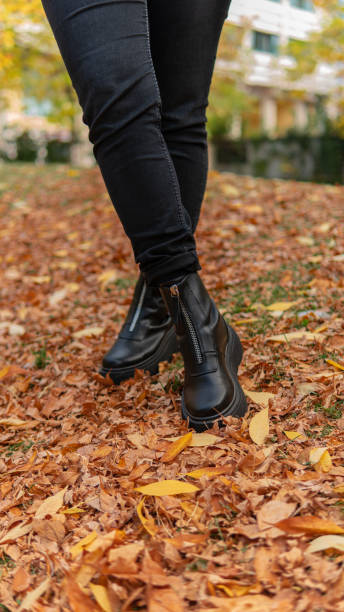 istock Woman wearing black boots over fall leaves, copy space 1434370638