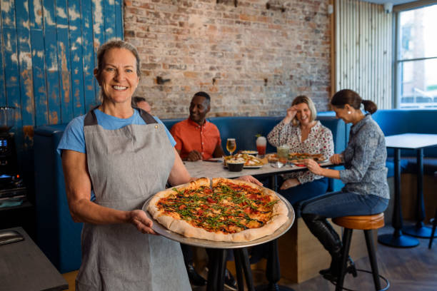 servir une pizza aux clients - pizza pizzeria restaurant waiter photos et images de collection