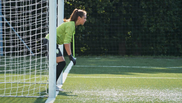 istock Female goalkeeper standing near goal post 1434372359