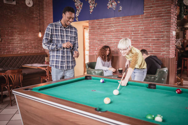 istock Group of friends playing pool in the pub 1434374502