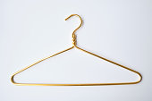 Gold clothes hanger on a light background. Smart consumption or sales concept
