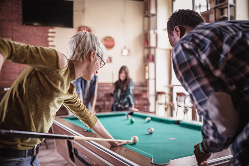 Group of friends playing pool in the pub