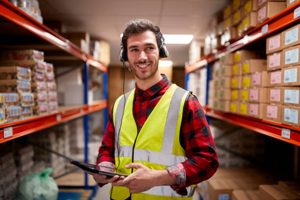 istock Portrait Of Male Worker Wearing Headset In Logistics Distribution Warehouse Using Digital Tablet 1434375831