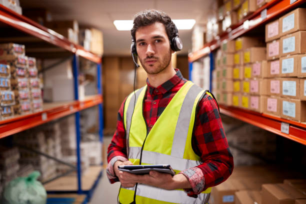 istock Portrait Of Male Worker Wearing Headset In Logistics Distribution Warehouse Using Digital Tablet 1434375898